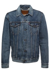 Jeansjacka i mörkblått med knäppning fram, spetsig krage, två bröstfickor och subtila blekningar. Har långa ärmar och rak passform.