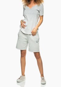 Světle šedé bavlněné tričko s výstřihem do V a krátkým rukávem, doplněné o odpovídající šedé kraťasy s detailem loga.