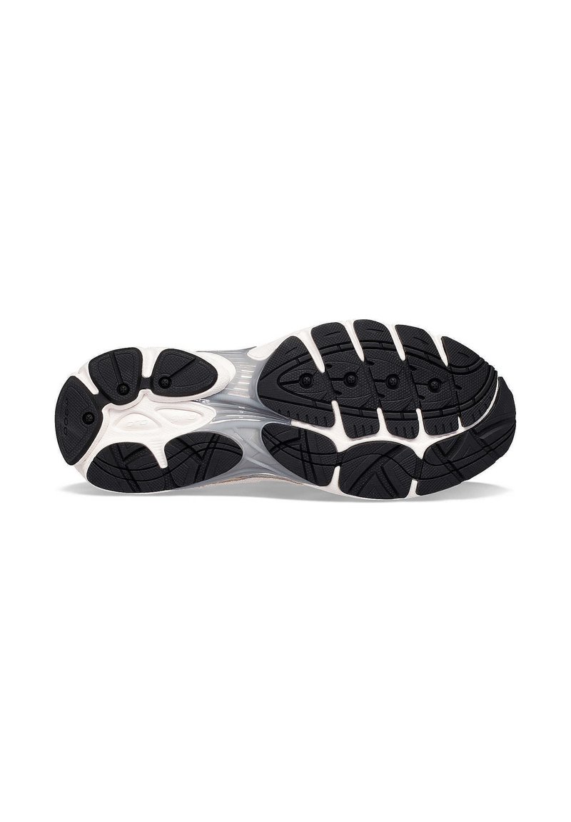 Suola di scarpa sportiva bianca e nera con battistrada in gomma testurizzata, caratterizzata da scanalature flessibili e motivi distintivi per una migliore aderenza.