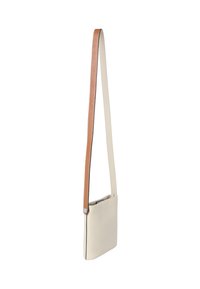 Malá obdélníková béžová kožená crossbody taška s dlouhým nastavitelným dvoubarevným popruhem, hnědým na jedné straně a béžovým na druhé.