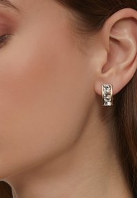 Goldfarbene Ohrringe mit drei rechteckigen klaren Kristallen in einem eleganten, modernen Design, das eine polierte Oberfläche und klare Linien betont.