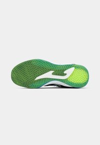Semelle de chaussure conçue pour la traction, avec un caoutchouc texturé vert, un accent courbé blanc et une semelle intermédiaire noire.