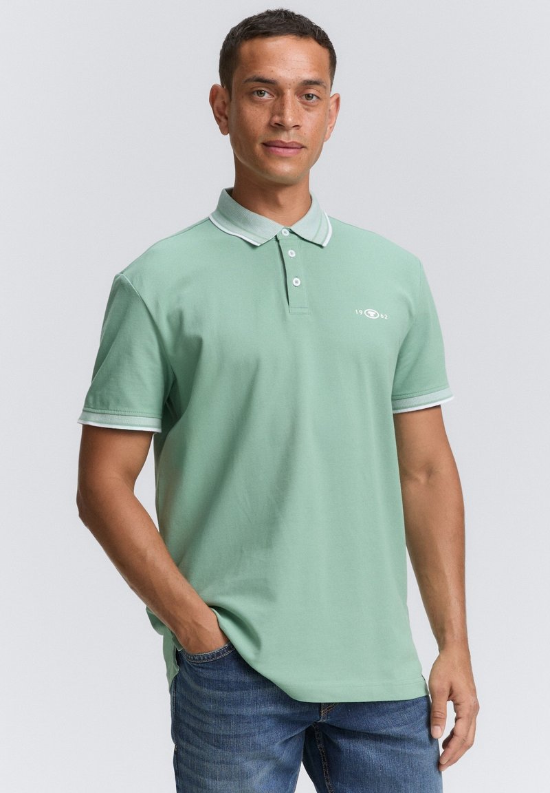 Polohemd aus mintgrüner Baumwolle, mit klassischen Kragen und kontrastierendem weißen Besatz, drei Knöpfen und einem dezenten Logo auf der Brust.