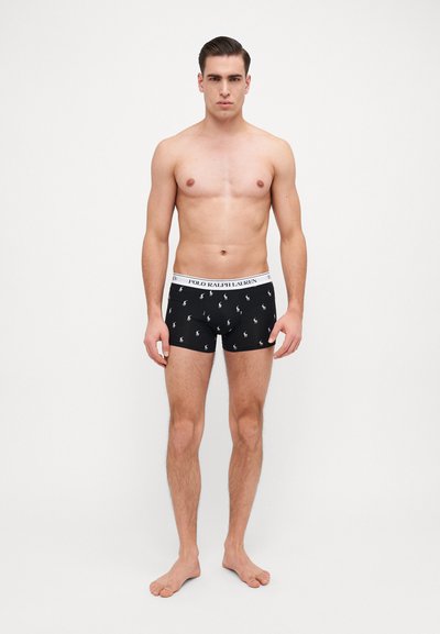 Černé boxerky s bílým elastickým pasem, na kterém je nápis "POLO RALPH LAUREN", zdobené malými vzory loga po celém povrchu.