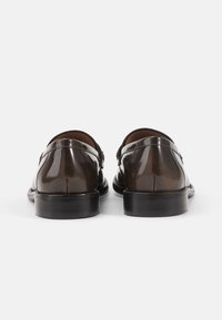 Tamno smeđe kožne cipele s poliranim sjajem, elegantnog dizajna, zaobljenog vrha i crnim gumiranim potplatom, s diskretnim detaljima šavova.