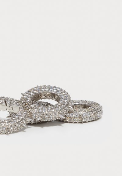 Silver-tone rings with textured surfaces, embellished with clear crystals and featuring pointed accents along the edges.