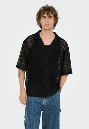Black short-sleeve shirt with intricate lace-like pattern, featuring a relaxed fit, button closure, and a flat collar.