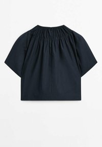 Top nero a maniche corte con scollo plettato e vestibilità rilassata. Realizzato in tessuto leggero, presenta un design semplice senza motivi.
