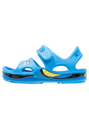 Sandale bleue pour enfants avec sangle ajustable, motif d'aile noir et jaune sur la semelle et un graphique de personnage sur la sangle avant.