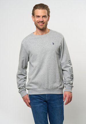Grå hettegenser laget av bomullsblanding, med rund hals, lange ermer, ribbestrikkede mansjetter og nederkant, med liten logo på brystet og tekst på ermene.