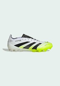 White and neon yellow Adidas Predator soccer cleat with black stripes and a textured upper, shown in left side profile view.