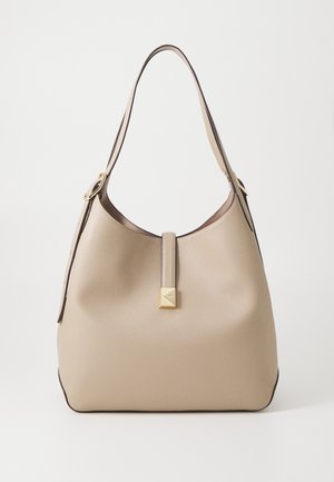 Tan leather handbag with a soft, rounded shape, featuring a gold square accent and a long shoulder strap. Smooth texture and minimal design.