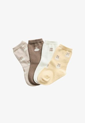 Fire par små børnestrømper i beige, brun, hvid og lys gul med små bamse-motiver og skridsikre prikker på det gule par.