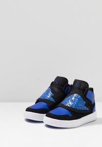 Černé a modré sportovní boty s polovičním kotníkem, se strukturovaným modrým svrškem, černými detaily a bílou gumovou podrážkou. Stříbrný detail loga.