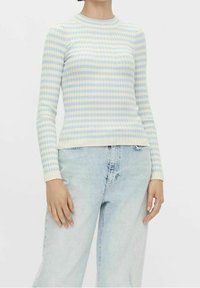 Světle modrý a bledě žlutý pruhovaný dlouhý rukáv z jemného žebrovaného materiálu. Kulatý výstřih, přiléhavý střih, spojený se světle modrými džíny.