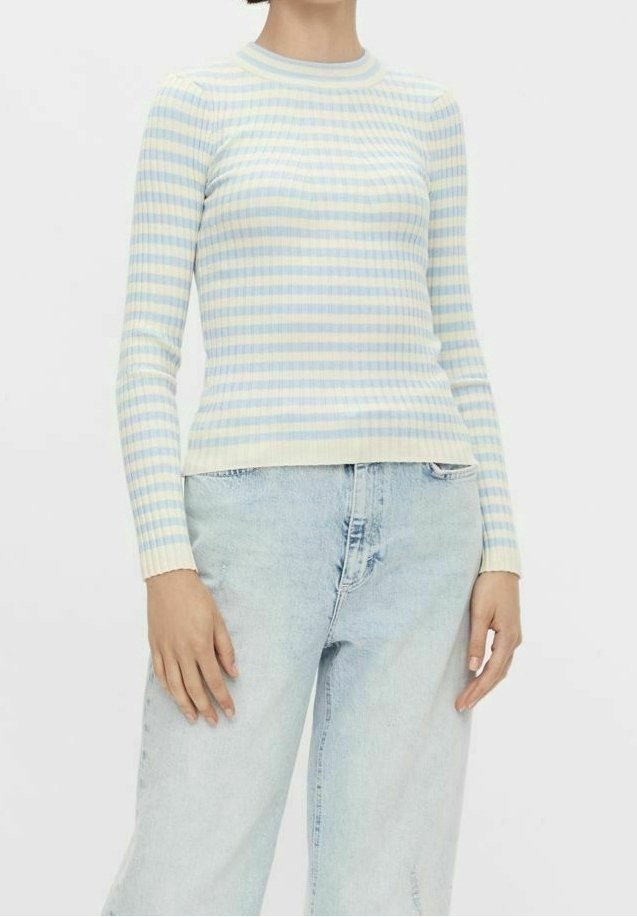 Světle modrý a bledě žlutý pruhovaný dlouhý rukáv z jemného žebrovaného materiálu. Kulatý výstřih, přiléhavý střih, spojený se světle modrými džíny.