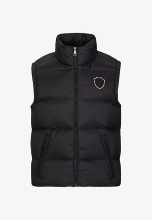 Zwarte gewatteerde vest met hoge kraag, volledig voorrits en twee zijzakken. Heeft een schildembleem in rode, groene en witte steken.