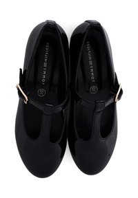 Ballerine in vernice nera con design a T-strap, hardware dorato e soletta imbottita. Forma sagomata con punta arrotondata.