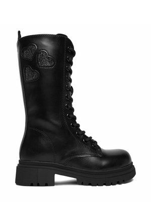 Stivale da combattimento in pelle nera con lacci, con tre toppe a forma di cuore glitterate sul lato esterno superiore e suola chunky.