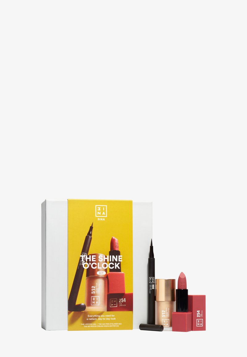Sminkesett med flytende highlighter, svart flytende eyelinerpenn og dempet rosa leppestift med innpakning merket "The Shine O'Clock."