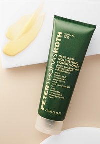 Tube souple vert de l'après-shampoing nourrissant Mega-Rich de Peter Thomas Roth, 235 mL, avec du texte doré ; produit crémeux et jaune sur une surface blanche.