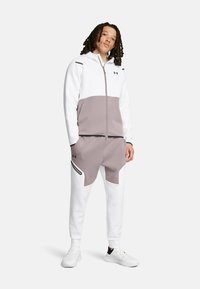 Zweiteiliges Sportbekleidungsset in Weiß und Hellgrau. Zip-Jacke mit Color-Blocking-Design; Hose mit seitlichen Reißverschlusstaschen und kontrastierenden Akzenten.
