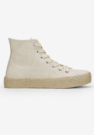 Zapatillas altas de lona beige con cordones beige, que cuentan con una suela de plataforma de yute trenzado. Ojetes de metal simples y tejido texturizado.