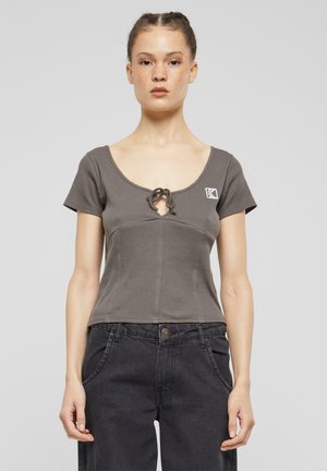Gray cropped top with short sleeves, featuring a round neckline, a front tie detail, and a small logo patch on the left chest.