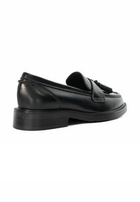 Black leather loafer shoe with a rounded toe, flat rubber sole, and decorative tassel detail on the front. Smooth texture and minimal stitching.