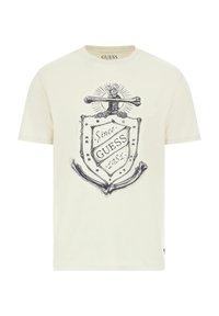 Camiseta color crema de algodón con cuello redondo. Presenta un diseño gráfico en negro con un escudo, ancla y estrellas.
