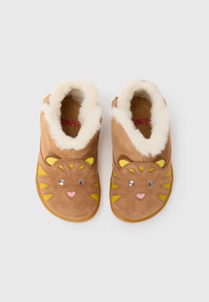 Bruine suède pantoffels met nep bontvoering, met een ontwerp van een leeuwengezicht met gele accenten en een roze hart op de neus. Rubberen zool.