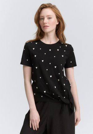 Zwarte T-shirt met een ronde hals, voorzien van een patroon van kleine witte en roségouden hartjes. Vastgebonden in de taille, gemaakt van zacht materiaal.