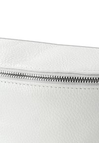 White leather bag with a textured surface, featuring a silver zipper along the top. Edges are stitched, providing durability.