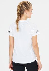 T-shirt de sport blanc à manches courtes, texture en maille, avec le logo "ELITE LAB" sur l'épaule. Conçu pour le sport avec une coupe décontractée.