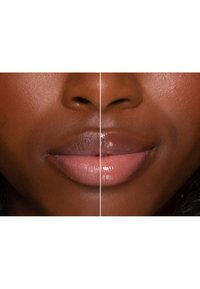 Close-up van lippen verdeeld in twee secties. De linkerkant heeft een matte lichtroze tint; de rechterkant heeft een glanzende nude afwerking. Gladde textuur.