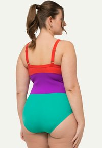 Maillot de bain une pièce présentant des panneaux rouges, violets et verts. Fabriqué en tissu lisse avec des bretelles réglables et un design à couverture modérée.
