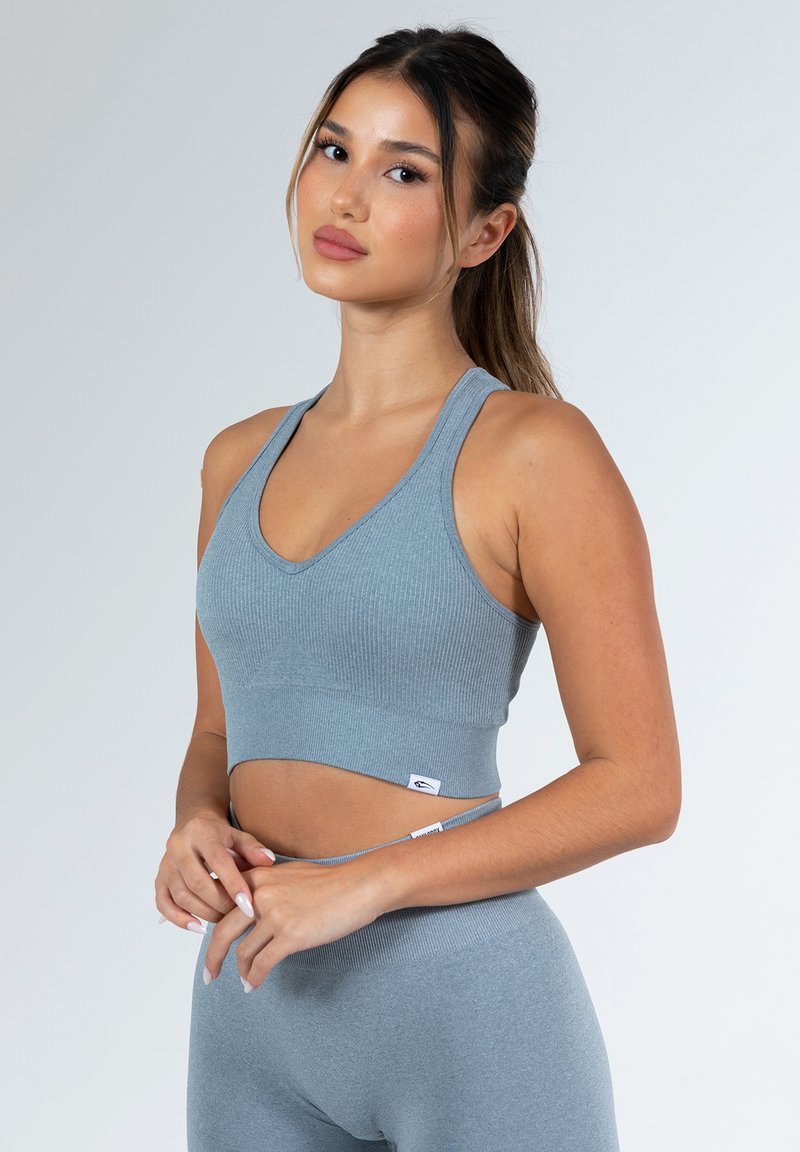 Grijze geribbelde sportcrop top met een V-hals en brede bandjes. Heeft een aansluitend ontwerp en een logo-label aan de zoom. Gekocht met bijpassende grijze leggings.