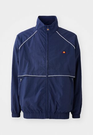 Marineblauwe windbreaker jacket met een hoge kraag, witte biesdetails, een rits aan de voorkant en twee zijzakken. Merken op de borst.