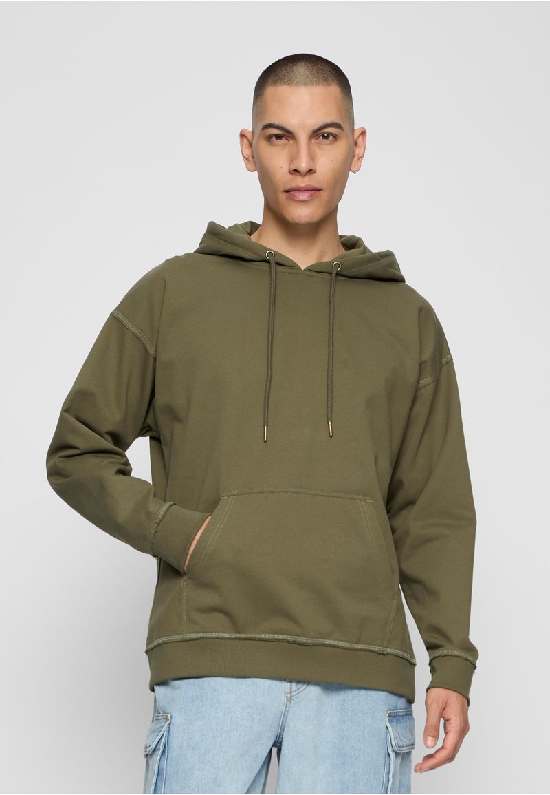 Oliiviroheline kapuutsiga dressipluus paela ja kängurutaskuga ees, soonikutega varrukaotstes ja alläärtes. Valmistatud pehmest kangast, lõdva sobivusega.