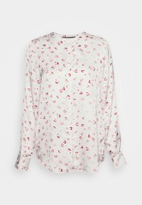 Blouse à manches longues en tissu léger, avec une base blanche ornée de petits motifs floraux rouges et roses. Texture douce et coupe décontractée.