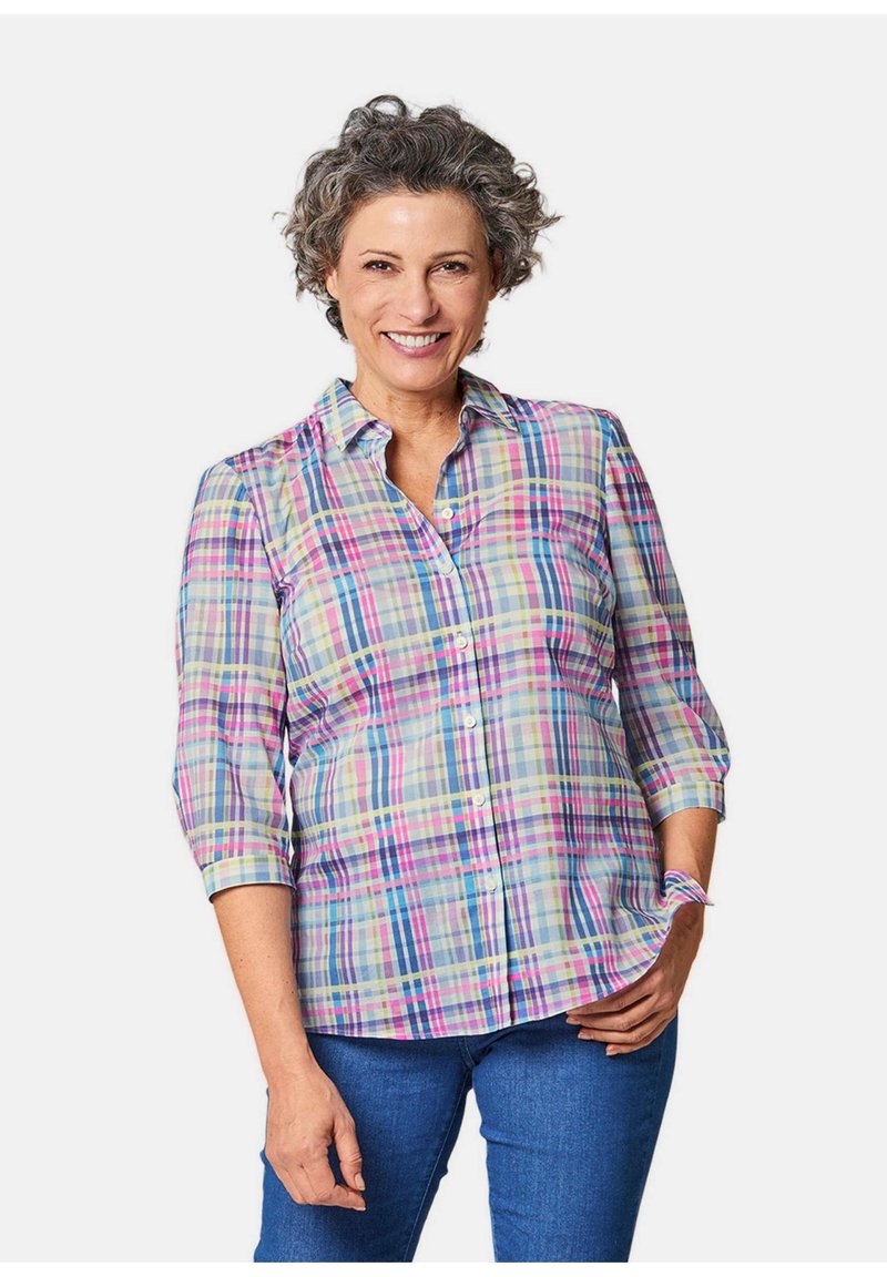 Camicia a quadri in colori pastello, con colletto, maniche a tre quarti e vestibilità rilassata. Indossata con jeans blu.