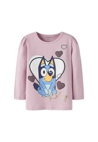 Lyserød langærmet skjorte med et cartoon blåt hunde, hjerter og teksten "Bluey" i guld. Fremstillet af blødt, strækbart stof.