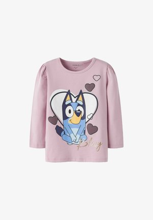 Langärmliges, hellrosa Shirt mit einem Cartoon-blauen Hund, Herzen und dem Text "Bluey" in Gold. Hergestellt aus weichem, dehnbarem Stoff.