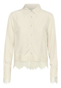 Kreemja blouse kaelusega ja nööpidega esiosas. Omab pikki varrukaid ning pitsist äärist hemmi ja varrukaotsade juures, lisades delikaatset detaili.