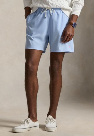 Lyseblå badeshorts lavet af hurtigtørrende stof, med elastik i taljen og snøre samt sidelommer. Lyserød logodetalje.