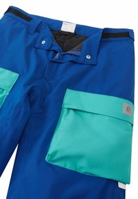 Blue waterproof pants with teal side pockets. Features zippers, snaps, and fabric tag inside the waistband. Smooth, durable material.