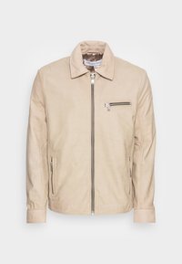 Beige Lederjacke mit Reißverschluss vorne, Stehkragen und Reißverschlusstasche auf der Brust. Sie verfügt über seitliche Taschen und hat eine glatte, weiche Textur.