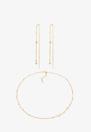 Ensemble de bijoux en or comprenant de longues et fines boucles d'oreilles avec des perles et un bracelet de cheville assorti orné d'un charme en croissant et de petites perles décoratives.