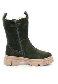 Botín de ante verde con cremallera lateral, suela de goma beige y acabado texturizado. Presenta un acento en azul marino en el costado.