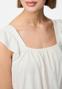 Top in lino bianco con scollatura quadrata e maniche corte a balze con dettagli arricciati. Texture morbida e aspetto leggero e arioso.